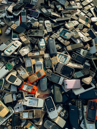 Technician sorting electronic waste components including hard drives and circuit boards for material recovery