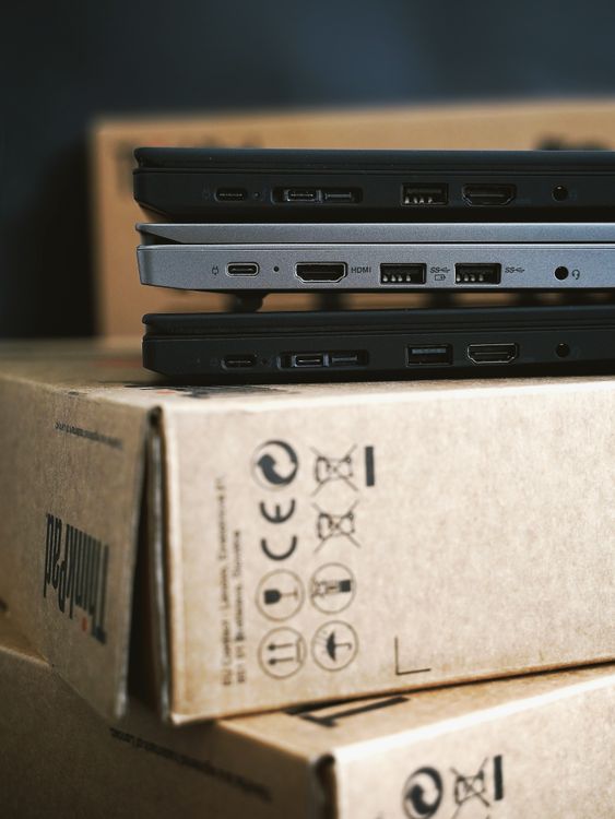Stack of laptops on cardboard boxes ready for EOFY IT disposal and data destruction
