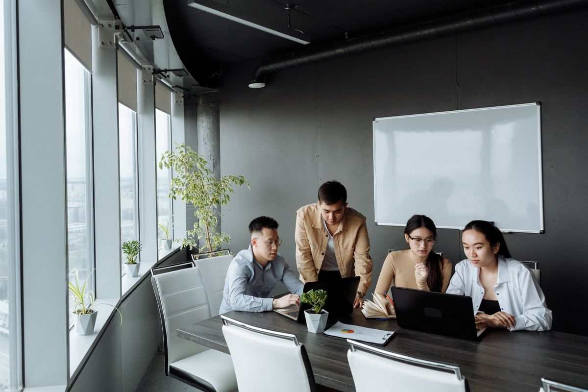 Stack of business laptops on an office conference table grouped for collection, representing end-of-lease IT equipment return and data destruction compliance